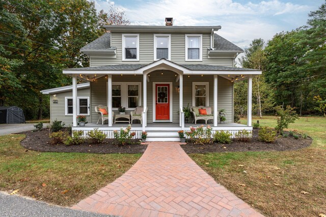 459 Durham Rd, Brunswick, ME 04011 - farmhouse inspired home featuring covered porch, a front yard, a shingled roof, and a chimney