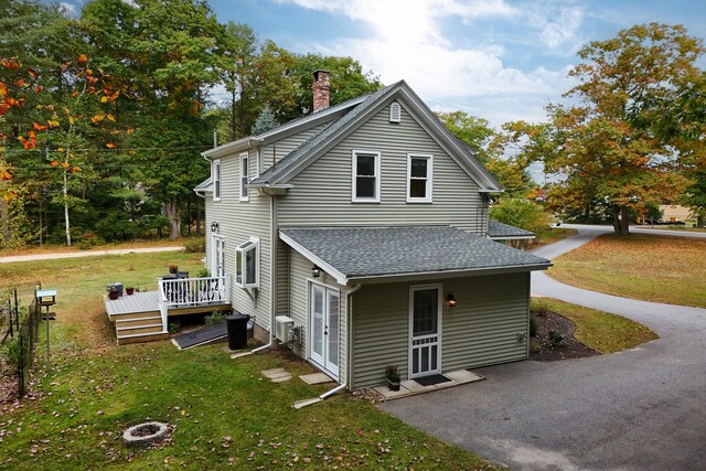 459 Durham Rd, Brunswick, ME 04011 - view of side of home with a wooden deck, a chimney, a lawn, roof with shingles, and a patio area