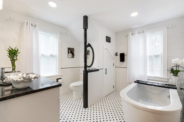 459 Durham Rd, Brunswick, ME 04011 - bathroom featuring tile walls, a tub, toilet, a wainscoted wall, and vanity
