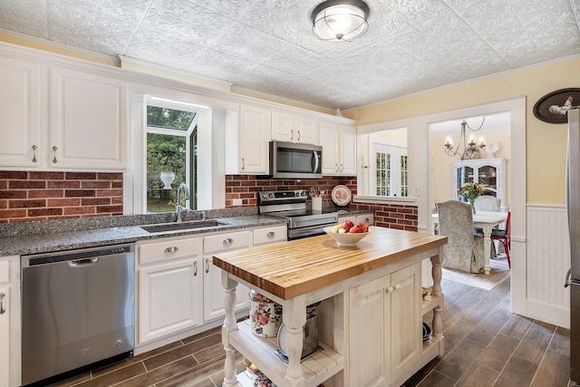 459 Durham Rd, Brunswick, ME 04011 - kitchen featuring stainless steel appliances, butcher block counters, a sink, dark wood-style floors, and an ornate ceiling
