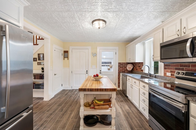 459 Durham Rd, Brunswick, ME 04011 - kitchen featuring appliances with stainless steel finishes, a sink, wood counters, an ornate ceiling, and dark wood-style flooring