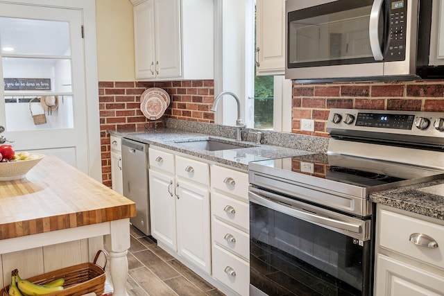 459 Durham Rd, Brunswick, ME 04011 - kitchen with appliances with stainless steel finishes, a sink, white cabinetry, and light stone countertops