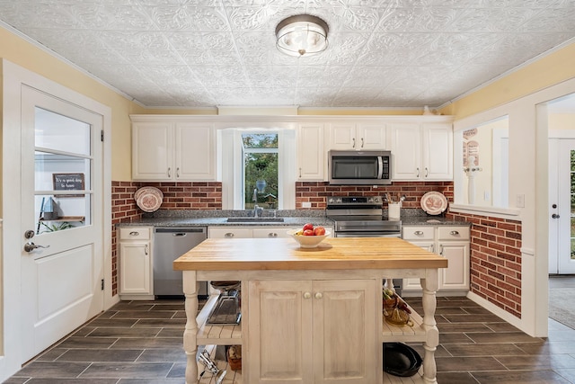 459 Durham Rd, Brunswick, ME 04011 - kitchen featuring stainless steel appliances, butcher block counters, wood finish floors, an ornate ceiling, and a kitchen island