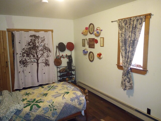 bedroom featuring dark hardwood / wood-style floors and a baseboard heating unit