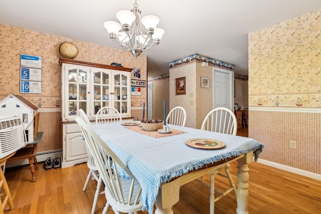 dining area with a notable chandelier and light hardwood / wood-style floors