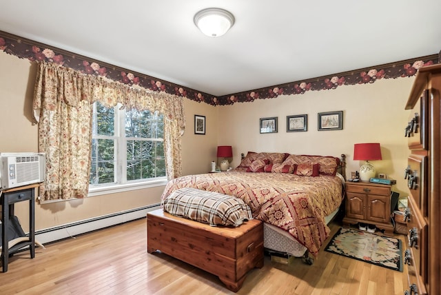 bedroom with a baseboard radiator, cooling unit, and light hardwood / wood-style floors