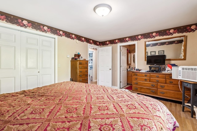 bedroom featuring a closet, hardwood / wood-style floors, and an AC wall unit