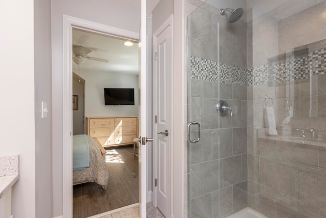 bathroom with wood-type flooring, walk in shower, vanity, and ceiling fan