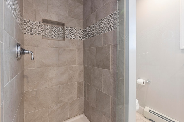 bathroom with a baseboard radiator, toilet, and tiled shower