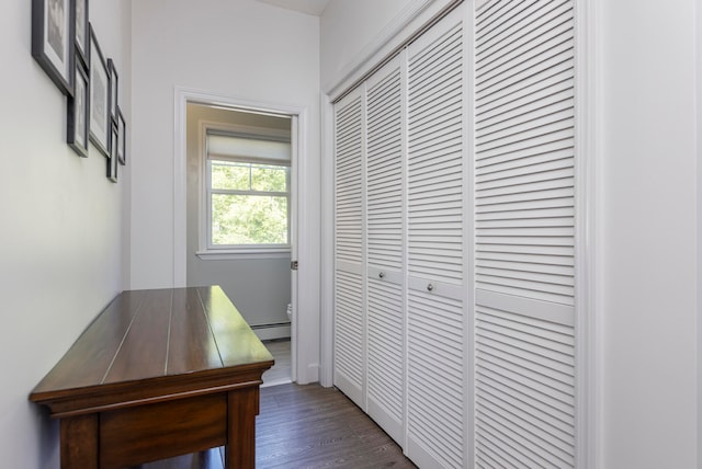 corridor featuring dark wood-type flooring and baseboard heating