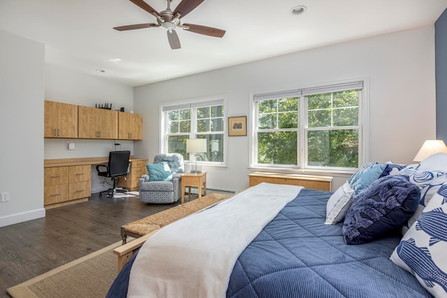 bedroom featuring ceiling fan, baseboard heating, built in desk, and dark hardwood / wood-style flooring