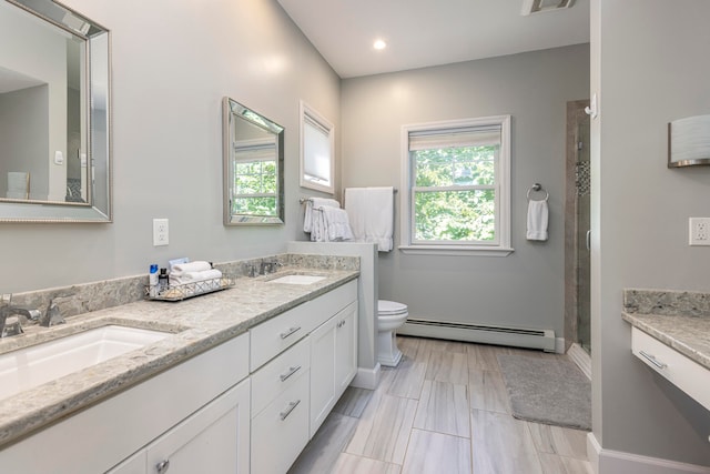 bathroom with vanity, a shower with shower door, toilet, and a baseboard heating unit