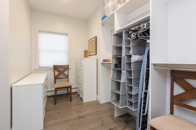 spacious closet with wood-type flooring and baseboard heating