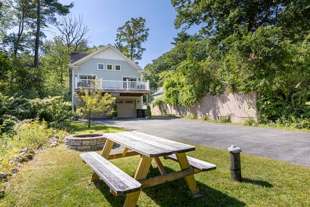 view of front of home featuring a front yard, a fire pit, and a garage