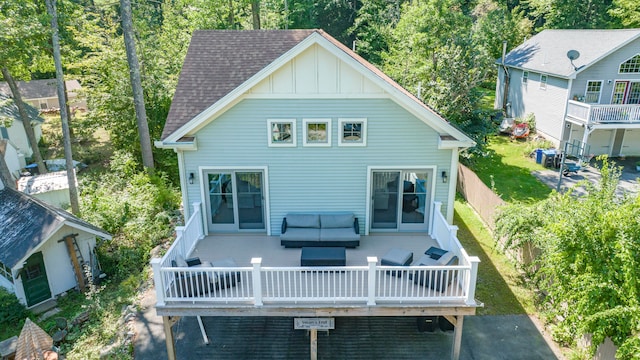 back of house with outdoor lounge area, a wooden deck, and a patio area