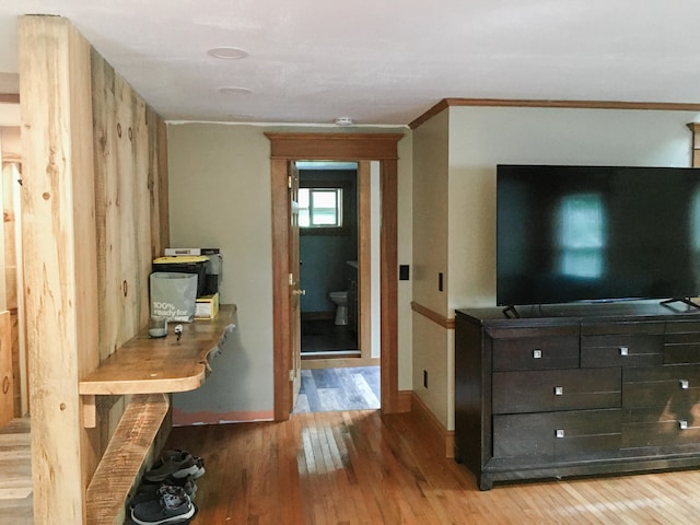 interior space featuring ornamental molding, wooden walls, and hardwood / wood-style floors