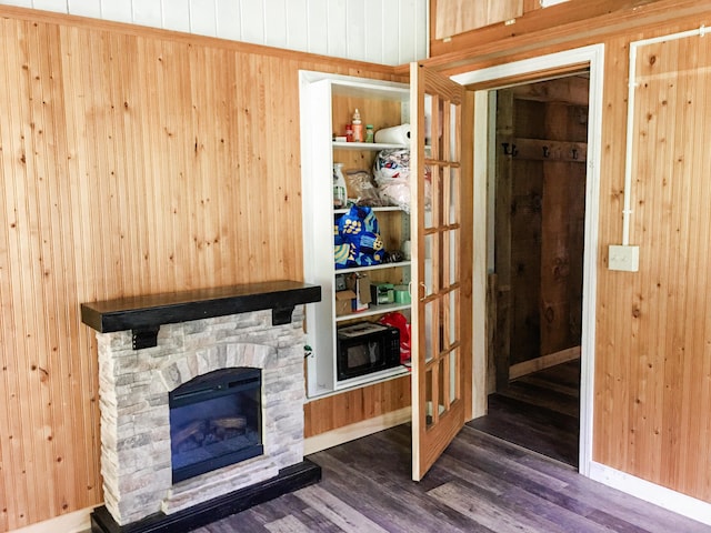 552 Egypt Rd, Alna, ME 04535 - living room featuring dark wood-style flooring, a stone fireplace, and wooden walls