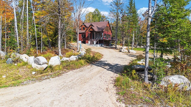 view of road featuring driveway and a view of trees