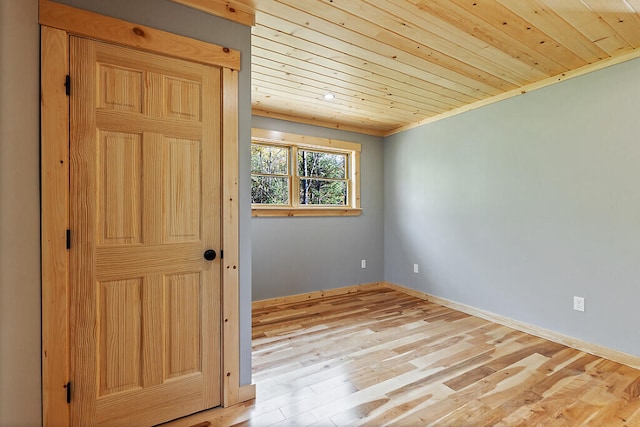 spare room featuring wooden ceiling, ornamental molding, and light hardwood / wood-style flooring