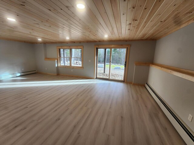 empty room with light hardwood / wood-style floors, a baseboard heating unit, and wood ceiling