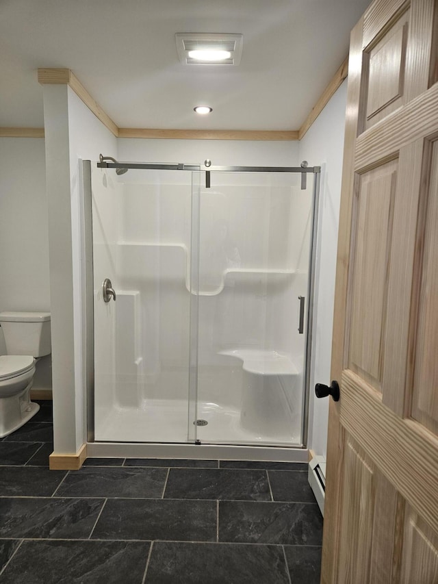 full bathroom with baseboards, baseboard heating, toilet, and a stall shower