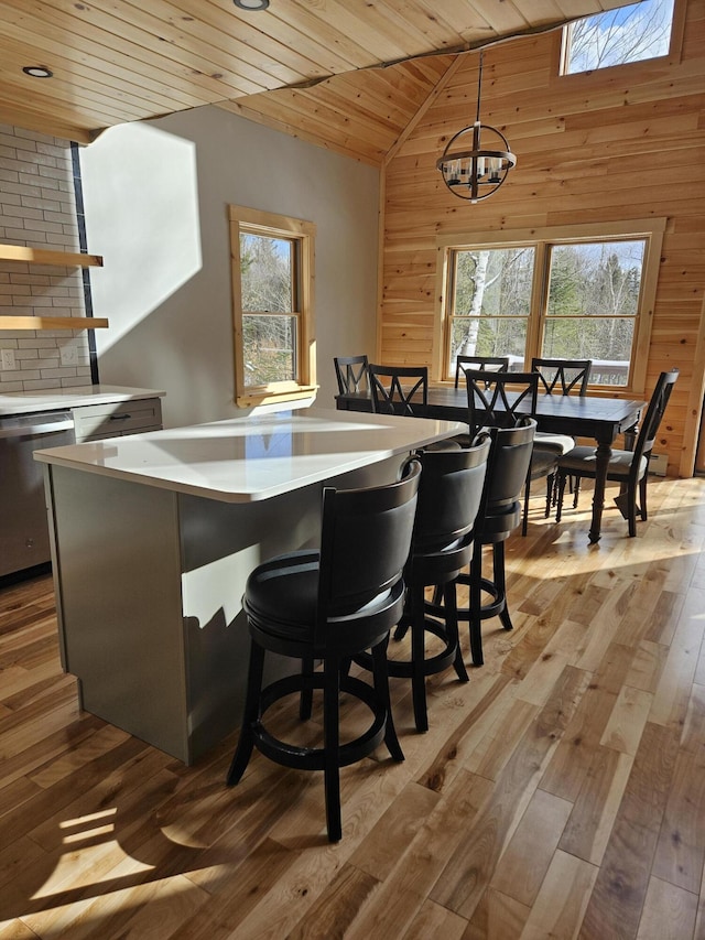 bar with dishwasher, wooden ceiling, wood finished floors, and wooden walls