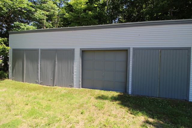 garage featuring a yard and wooden walls