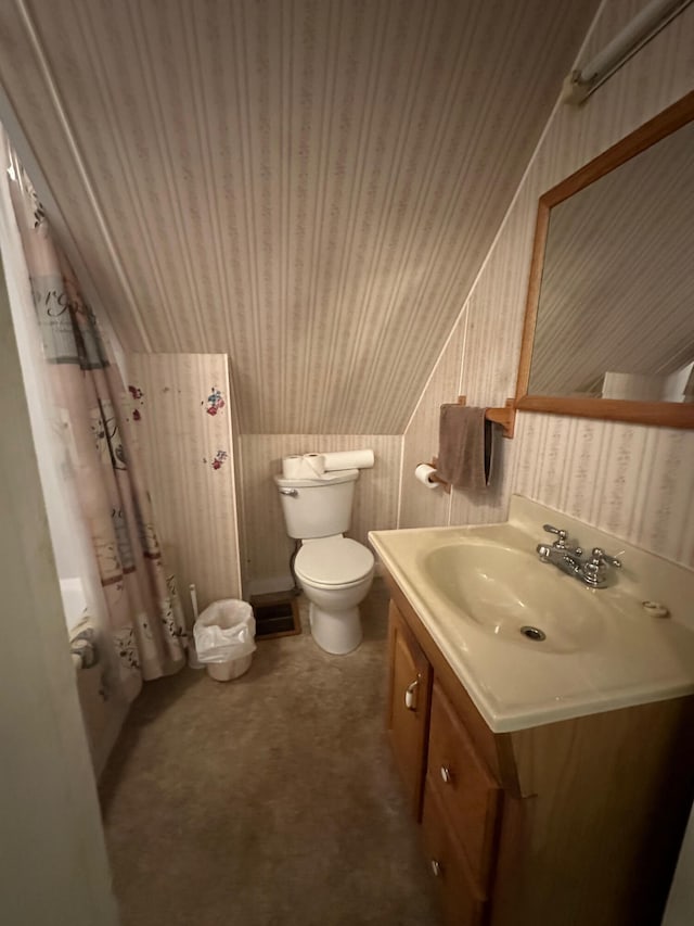 bathroom with vanity, vaulted ceiling, curtained shower, and toilet