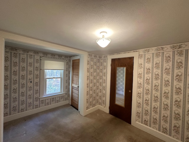 carpeted entrance foyer with a textured ceiling