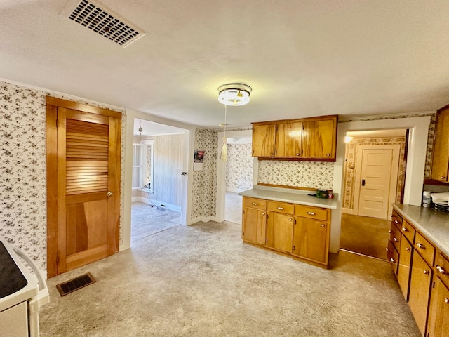 kitchen with crown molding, a textured ceiling, and light colored carpet