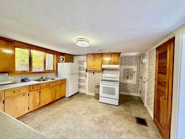 kitchen with white appliances, a textured ceiling, and sink