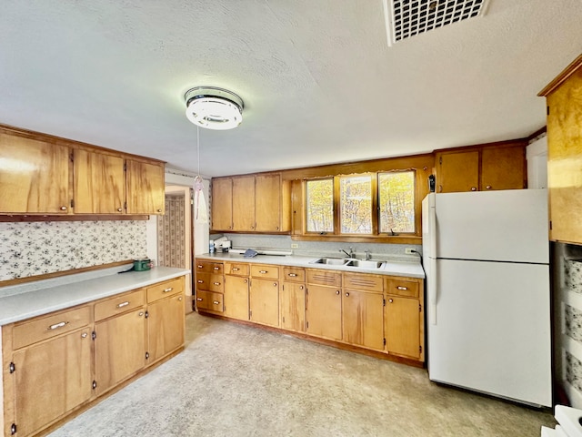 kitchen featuring light carpet, a textured ceiling, sink, and white refrigerator