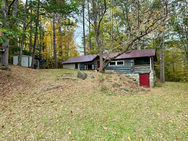 view of front facade featuring a storage shed and a front lawn