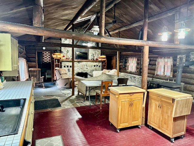 miscellaneous room with beam ceiling, ceiling fan, high vaulted ceiling, a stone fireplace, and rustic walls