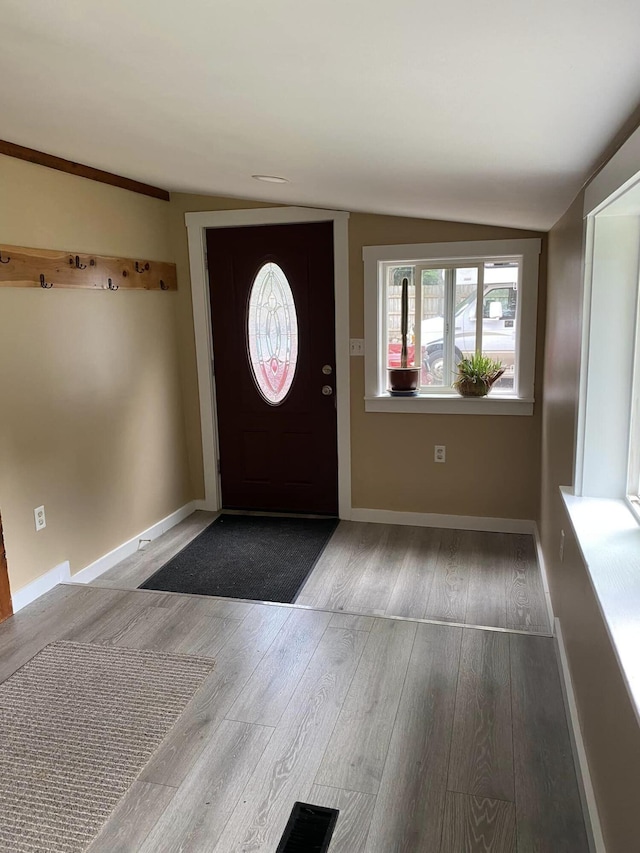 foyer entrance with vaulted ceiling and hardwood / wood-style flooring