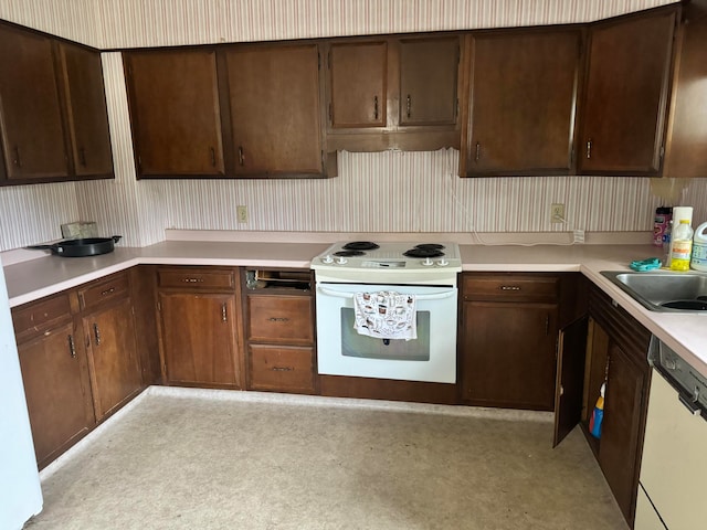 kitchen featuring dark brown cabinets, white appliances, and sink