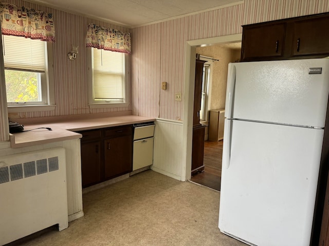 kitchen with dark brown cabinetry, light carpet, radiator heating unit, and white refrigerator