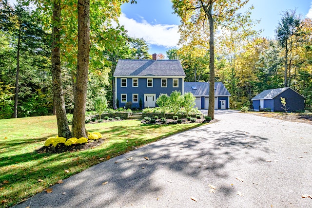 colonial house featuring a front lawn and a garage