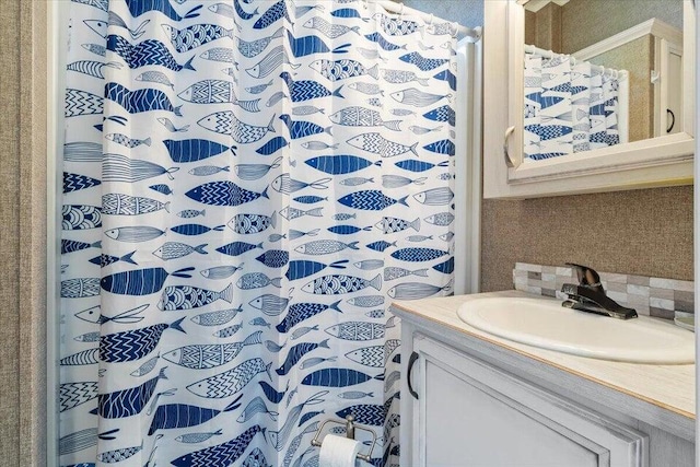 bathroom featuring walk in shower, backsplash, and vanity