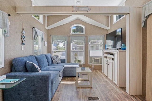 living room featuring lofted ceiling with beams and hardwood / wood-style flooring