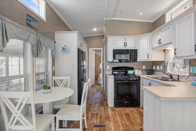 kitchen with light hardwood / wood-style floors, white cabinetry, black appliances, sink, and plenty of natural light