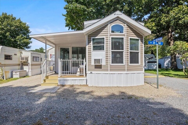 rear view of property with covered porch and driveway