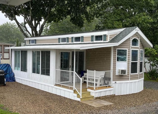 rear view of house featuring cooling unit and a porch