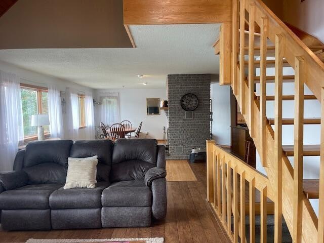 living room with a brick fireplace and hardwood / wood-style flooring