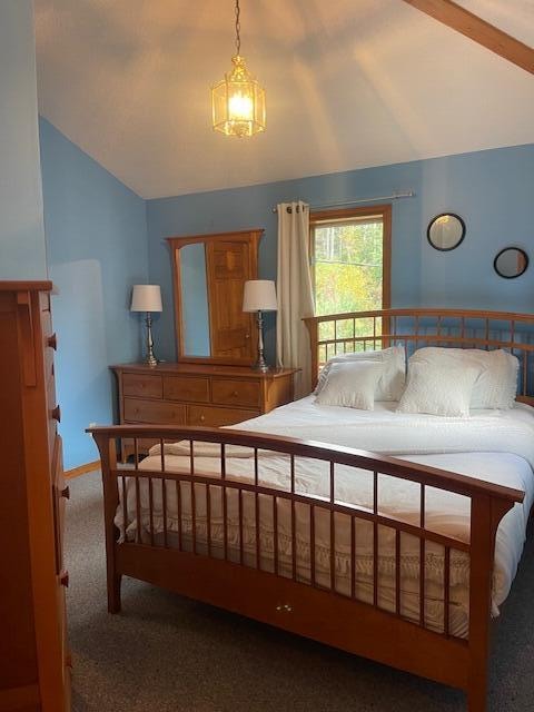 carpeted bedroom featuring lofted ceiling