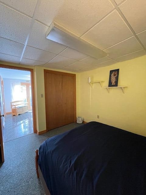 carpeted bedroom with a drop ceiling