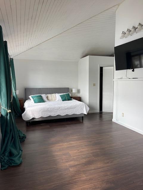 bedroom with lofted ceiling and dark wood-type flooring