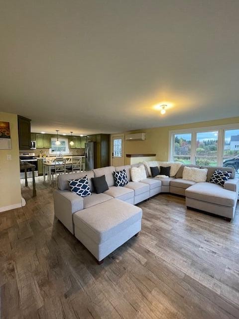 living room with dark hardwood / wood-style flooring and a wall unit AC