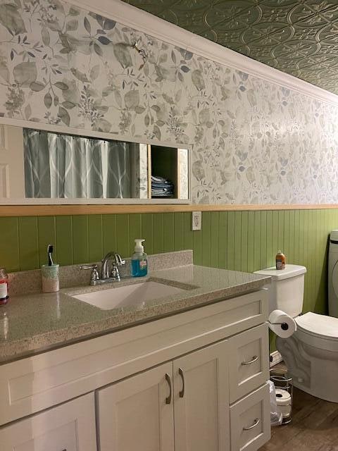 bathroom with vanity, crown molding, and toilet