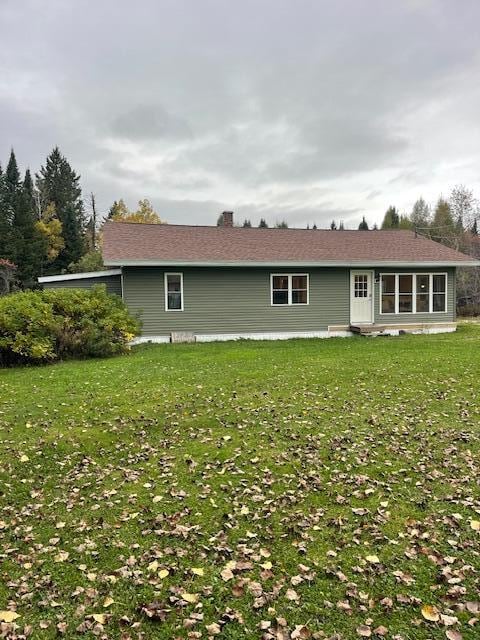 rear view of property featuring a yard